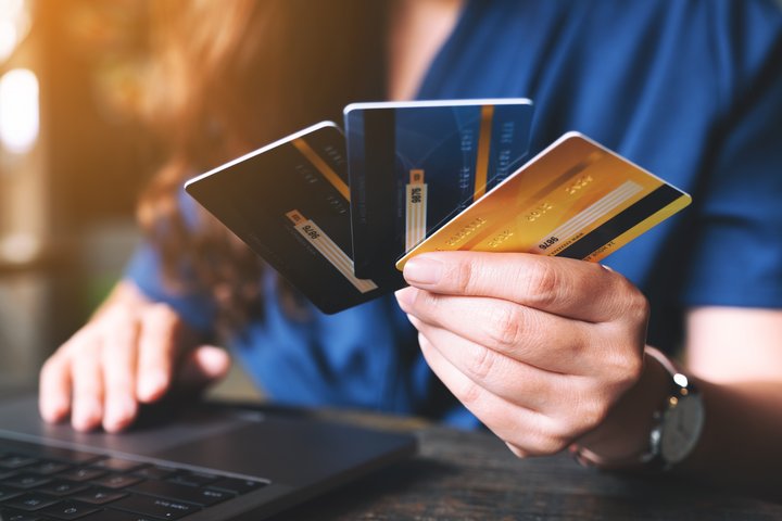 People holding  the best business credit cards while using laptop computer